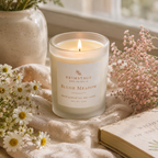 Lit luxury Blush Meadow Soy Wax candle surrounded by floral decoration.